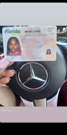 a woman is holding up a fake mercedes id card