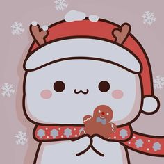 a white cat wearing a red hat and scarf holding a gingerbread in its paws