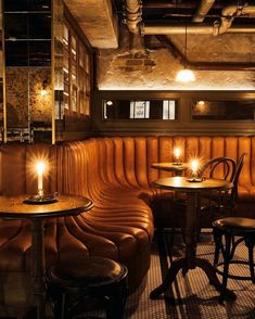 a dimly lit restaurant with leather booths and tables