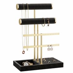 a black and gold jewelry rack with three rings, two watches and four necklaces