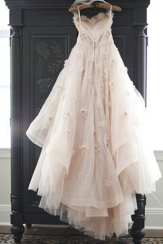 a dress hanging on a rack in front of a mirror