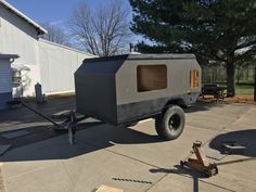 an off - road trailer is parked in front of a building