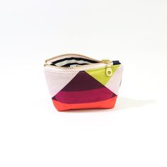 Introducing the Geometric Poofy Coin Pouch: a delightful blend of charm and versatility. This unique pouch combines a playful pink geometric pattern on one side with durable navy dry oilskin on the other, offering a stylish contrast that stands out. Measuring approximately 3.5" x 5" with a poofy, 1" gusseted design, this pouch not only holds your coins and small essentials but also stands on its own for easy access. The brass-colored metal zipper ensures secure closure, while adding a touch of vintage elegance to its modern design. Whether slipped into a purse or carried solo, the Geometric Poofy Coin Pouch is perfect for adding a pop of color and personality to your everyday carry. It's an ideal accessory for those who appreciate practicality without compromising on style. Multicolor Coin Purse With Removable Pouch As Gift, Gift Coin Purse With Removable Pouch In Multicolor, Gift Multicolor Coin Purse With Removable Pouch, Multicolor Zipper Coin Purse, Multicolor Pouch Coin Purse For Everyday Use, Multicolor Zipper Coin Purse For Everyday, Multicolor Compact Everyday Bag, Modern Coin Purse Pouch For Daily Use, Modern Coin Purse With Removable Pouch For Daily Use