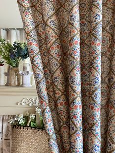 a close up of a curtain in a room with a fire place and vases on the wall