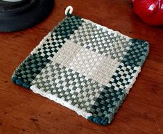 a close up of a piece of cloth on a wooden table with an object in the background