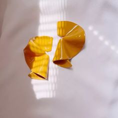 two pieces of yellow paper sitting on top of a white table