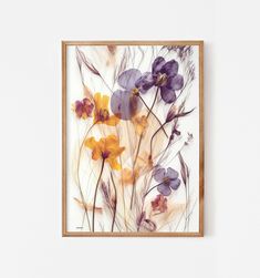 an art piece with flowers in it on a white wall next to a wooden frame