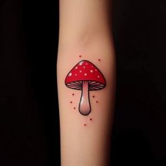 a red mushroom tattoo on the arm