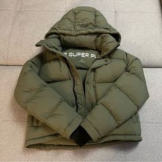 Xs Cropped Puffer Jacket From Aritzia. Limited Edition Army Green Color. Worn For Two Seasons But Decided To Get Another Puffer Jacket. Gently Used Condition. Some Small Signs Of Wear Around The Jacket But No Holes, And Still 100% Functional Features 100% Responsibly Sourced Goose Down Certified To The Responsible Down Standard Engineered To Deliver Warmth To -20c / -4f 700+ Fill-Power Goose Down Fabric From An Innovative Japanese Mill Water-Repellent Fabric Wind-Resistant Fabric Machine Washabl The Super Puff, Aritzia Jacket, Super Puff, Army Green Color, Cropped Puffer Jacket, Smart Storage, Water Repellent Fabric, Small Signs, Puffer Jacket