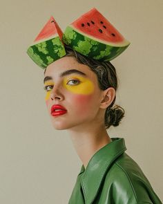 a woman with watermelon painted on her face and wearing a green leather jacket