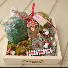 a wooden box filled with assorted items on top of a wood floor next to a string fence