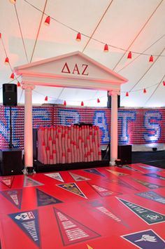 a red carpet covered in lots of signs and lights next to a white building with columns