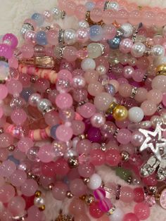 a pile of pink and white bracelets sitting on top of a table next to each other