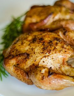 a close up of a chicken on a plate with garnishes and herbs