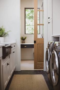 a washer and dryer in a room with a door leading to the bathroom