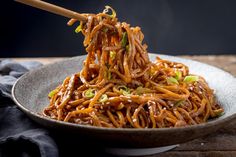 a bowl full of noodles with chopsticks in it