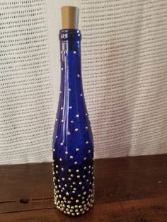 a blue glass bottle with gold dots on it