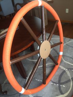 an orange and white wheel on top of a table with chairs in the back ground