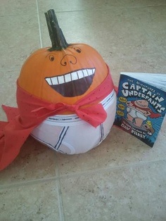 an inflatable pumpkin sitting next to a children's book on the floor