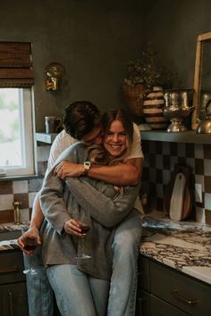 two people hugging each other in the kitchen