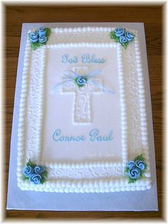 a cake decorated with blue roses and a cross