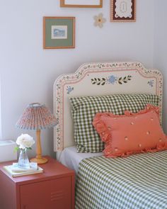 a bedroom with a bed, nightstand and pictures on the wall