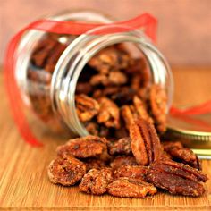 a jar filled with pecans sitting on top of a wooden table