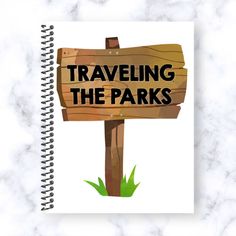 a notebook with the words traveling the parks on it and a wooden sign in front