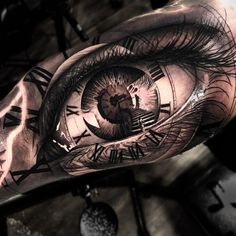 an eye tattoo on the arm with roman numerals and clock faces in it