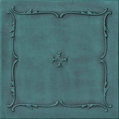 a square tile with an ornate design on the top and bottom, in teal green