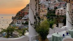 an outdoor dining area with tables and chairs overlooks the ocean in positi, italy