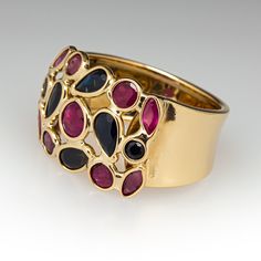 This Italian ruby and sapphire ring features round, marquise and pear cut rubies and sapphires set in to bezels across the top of the ring. It is crafted of 18k yellow gold and currently a size 7 and we are not offering resizing due to the design. Brand Presentation, Old Boxes, Ruby Sapphire, Pear Cut, Marquise Cut, October Birth Stone, High Quality Jewelry, Estate Jewelry, Sapphire Ring