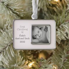 a baby's first christmas ornament hanging from a tree