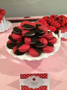 red and black cookies are arranged on a pink tablecloth with white polka dot dots