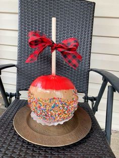 a cake with sprinkles and a bow on it sitting in a chair