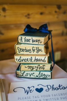 stack of books with writing on them sitting on top of a table next to cards