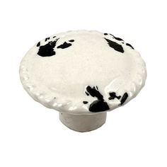 a black and white spotted mushroom knob on a white background with room for text or image