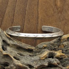 "Vintage sterling silver Native American cuff bracelet. The inside of the cuff measures 5 3/8\", the gap is 1\". The bracelet is approximately 1/4\" wide. There is a nice and simple stamp design. This cuff has a slight dimensional aspect to it as it tapers to a point along the center. Please feel free to message us with any questions. Thank you for shopping with us." Sterling Silver Cuff Bracelet Native American, Classic Stamped Cuff Bracelets, Classic Stamped Cuff Bracelet, Stamped Sterling Silver Cuff Bracelet, Classic Stamped Adjustable Cuff Bracelet, Classic Adjustable Stamped Cuff Bracelet, Sterling Silver Stamped Cuff Bangle, Sterling Silver Cuff Bracelet, Sterling Silver Cuff