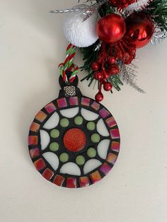 a stained glass ornament hanging from a christmas tree