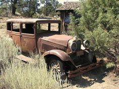 an old rusted out truck in the middle of nowhere