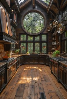 a large kitchen with wooden floors and windows on the ceiling is lit by sunlight streaming through the round window