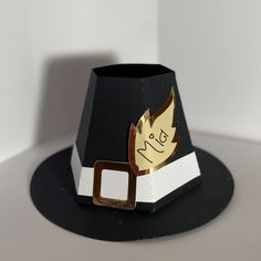 a black and white paper hat with gold foil on it