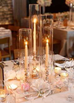 the table is set up with candles and wine glasses for an elegant dinnereon party