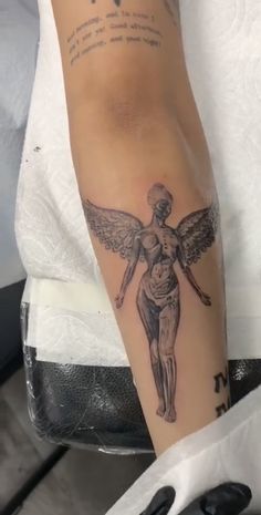 a woman's arm with an angel tattoo on the left side of her body