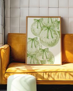 an art piece is displayed on a couch in front of a white brick wall and yellow leather chair