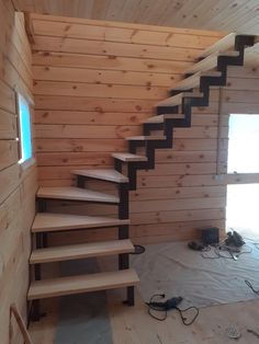 there is a stair case in the room with wood walls and flooring on it