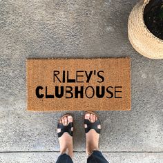 a person standing in front of a door mat that says jenny's playhouse