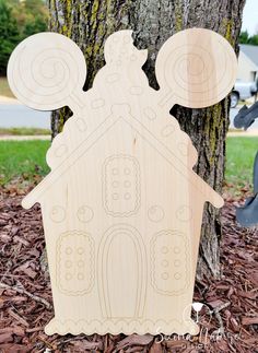 a wooden cutout of a house next to a tree