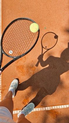 a person standing on a tennis court holding a racquet and ball in their hand