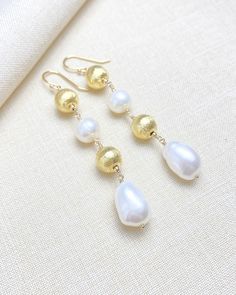 Light up the party with these bright, festive earrings. Shimmering brushed gold beads and organically shaped freshwater pearls are the epitome of coastal luxe. You can keep it fun and classy through the holidays and beyond. Earring drop length: 2.5 inches Materials: cultured freshwater pearls gold-plated copper beads gold-filled ear wires and components Festive Earrings, Coastal Luxe, Grey Pearl Necklace, Bead Drop Earrings, Earring Drop, Holiday Earrings, Sterling Silver Wire Wrap, Druzy Quartz, Beaded Drop Earrings